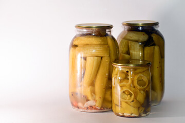 Vegetable marinade on white background. Canned sour vegetables in glass jars. Pickled vegetables in a jar - cucumbers, tomatoes, peppers, okra.