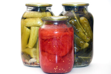 Vegetable marinade on white background. Canned sour vegetables in glass jars. Pickled vegetables in a jar - cucumbers, tomatoes, peppers, okra.