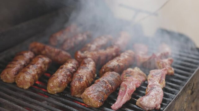 4k, with traditional Romanian product Mici on the grill during cooking.
