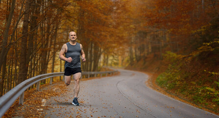 Man running on a winding road in autumn........