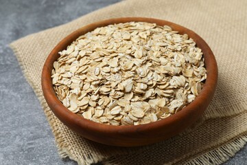 Composition with oatmeal flakes on gray background. Cooking breakfast