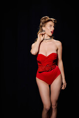 Elegant young woman in a stylish red outfit showcasing confidence on stage at night