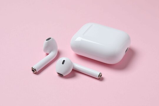 Wireless ear phones with a white box on color background 