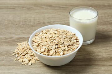 Composition with oatmeal flakes on wooden background. Cooking breakfast