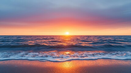 Obraz premium Sunset over ocean landscapes idea. Vibrant sunset over ocean waves reflecting warm colors on sandy beach.