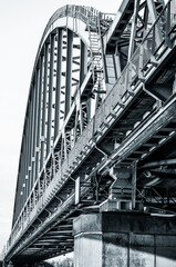 Fototapeta premium Vertical black and white picture of a railroad bridge in Utrecht, Netherlands. 