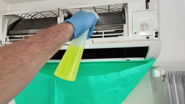Man cleaning and maintaining air condition unit at Man cleaning and maintaining air condition unit at home.