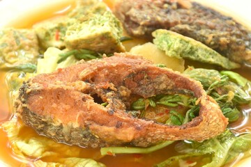 fried snake head fish and egg stuffed climbing wattle in spicy sour soup on plate
