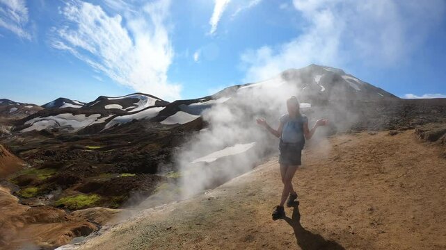 Female Hiker Exploring Kerlingarfj&ouml;ll Geothermal Area Among Colorful Rhyolite Mountains and Snow, Iceland