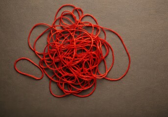 Red tangled string on gray background