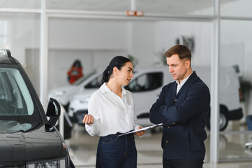 Man customer male buyer client consult with salesman signs documents choose auto