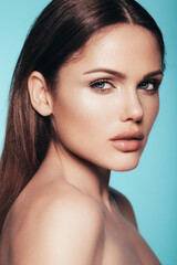 Obraz premium Fashion beauty portrait of young smiling brunette woman with natural makeup and perfect clean skin. Sexy model with long curly hair posing in studio