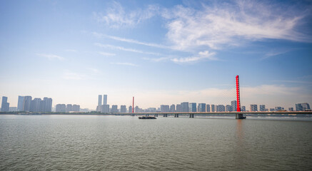 Stunning Cityscape with River and Modern Bridge Under Clear Sky