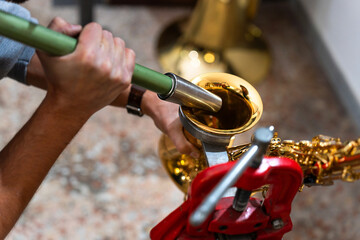 Luthier repairing saxophone bell with specialized tool