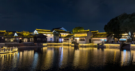 Fototapeta premium Serene Nightscape of Traditional Architecture Reflecting in Water