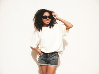 Beautiful black woman with afro curls hairstyle.Smiling hipster model in white t-shirt. Sexy...
