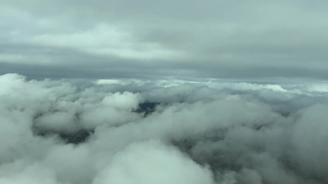 A pilo&rsquo;s POV FPV from a jet cockpit while flying between layers of cottony clouds in a stormy sky