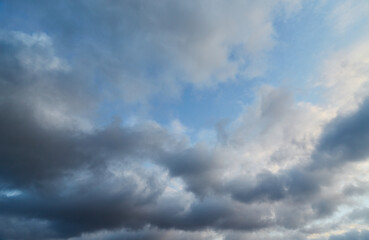 Fototapeta premium Dark clouds creeping over bright azure skies remind us of the changeability of weather and life circumstances. Symbolizes the cyclicity of nature.