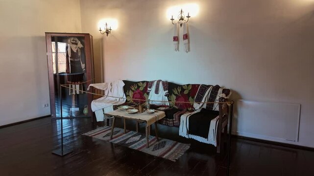 Traditional Romanian living room decor exhibited in the Corvin Castle with period furniture and clothes with cultural essence in Hunedoara, Romania.
