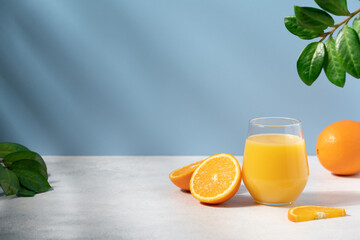 Orange juice or smoothie on blue background with copy space. Vitamin summer refreshing cocktail drink