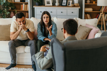 Young couple discussing problems with their psychologist in the living room