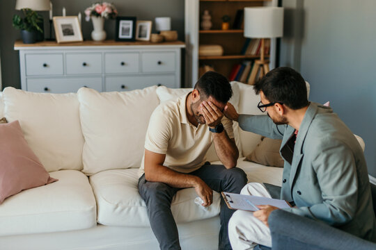 Psychologist comforting crying patient during therapy session