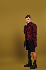 Stylish young man with prosthetic leg showcases fashionable attire in studio setting