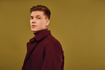 Handsome young man showcases trendy fashion in stylish studio setting