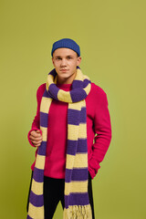 Handsome young man showcases trendy winter fashion in a vibrant studio setting