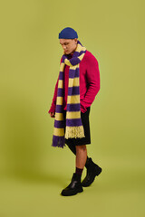 Handsome young man with a prosthetic leg shows off trendy fashion in a bright studio