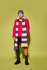 Young man showcasing stylish fashion with a prosthetic leg in a vibrant studio setting