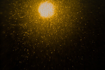 Blurred bokeh light sparkle on golden black background
