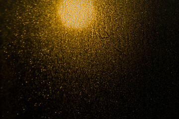 Blurred bokeh light sparkle on golden black background