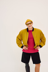 Handsome young man with a prosthetic leg showcases trendy fashion in a studio setting