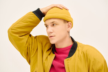 Young man showcases trendy winter outfit in a stylish studio setting