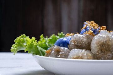 Colorful traditional dessert served on a white plate with fresh lettuce in a cozy setting