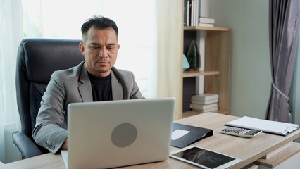 Asian Businessman working with Laptop at Office Desk