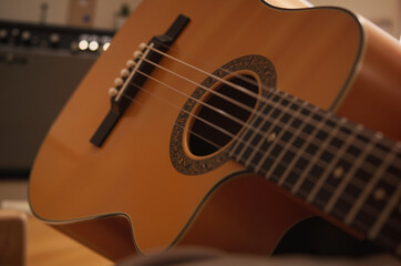 Fototapeta premium Resting Acoustic Guitar Against Amplifier – Warm Wooden Tones for International Youth Day and Music-Themed Content 