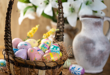 Decorated Easter eggs in a basket with white lilies