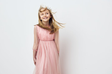 Smiling girl in a pink dress with flowing hair against a white background, embodying joy and...
