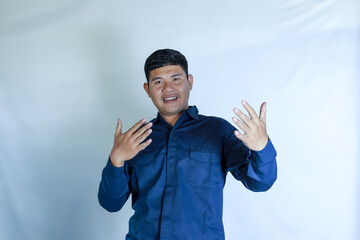 Young Asian man in blue shirt on white background gesturing to invite with happy gesture and expression