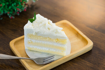 White coconut cake on wooden plate.