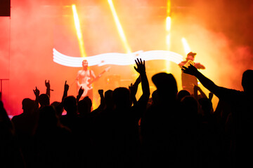 Crowd at concert and colorful stage lights.
