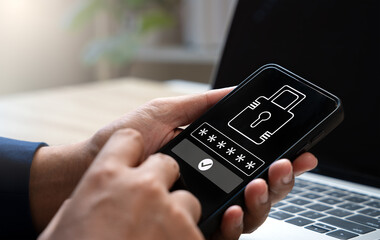 Cybersecurity and data protection, Businessman using smartphone and laptop to secure business data, Financial transactions, Personal information from cyberattacks with advanced network security.