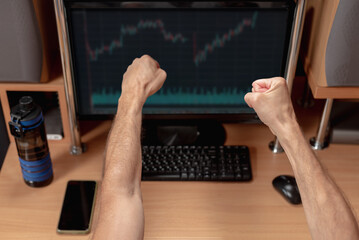Excited male trader nervously checking market charts. Man trading in free time, charts on home monitor, excited