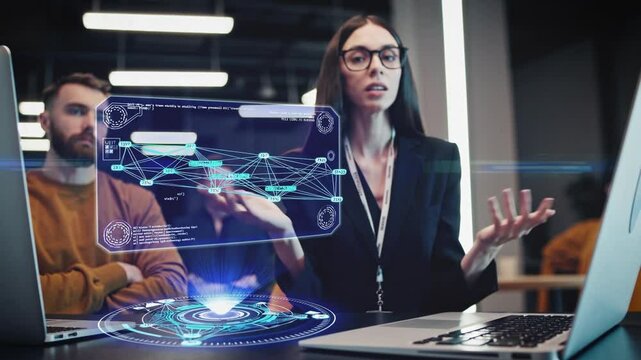 Female software engineer explaining a data visualization projected as a futuristic hologram in a tech-driven office. Colleagues listen attentively, engaging in an advanced discussion on data analysis