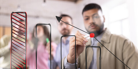 Businessman presenting financial growth projection, drawing rising bar chart with red highlights, emphasizing strategic expansion and company performance improvement. Concept of business development