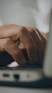 A pharmacy technician applies their expertise while typing on a laptop. This action takes place in a professional healthcare environment, focusing on patient care and consumer needs