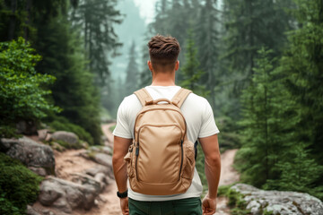 Naklejka premium Young man standing with his back, with beige trekking backpack, wearing white slim fit tee, walking on forest trail near mountain stream. Travelling, hiking, sports, active lifestyle designs mock