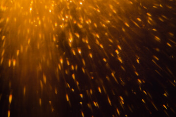 Blurred bokeh light sparkle on golden black background